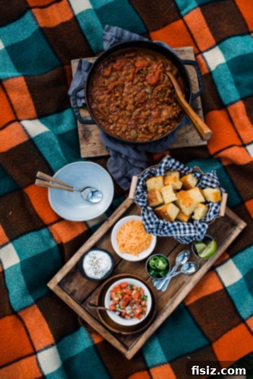 Legendary Lamb Chili 7 A wide shot of a fall picnic spread featuring Ultimate Lamb Chili, plaid blanket, and autumn decor.