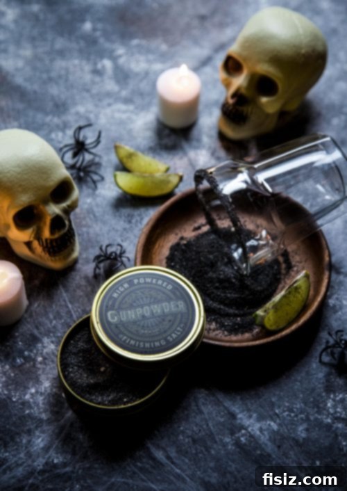 Fright Night Margarita 5 A festive Halloween setup featuring a spooky drink with a black salt rim, a small pumpkin, and fall leaves, creating a cozy and eerie autumn atmosphere.