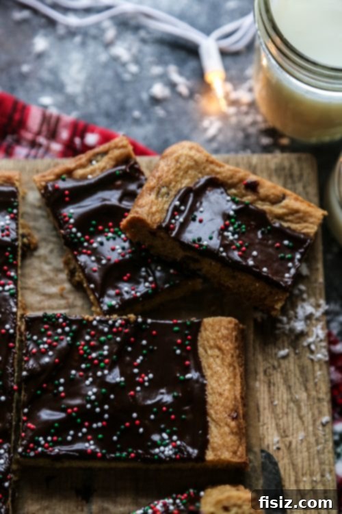 Peppermint Chocolate Chip Cookie Bars Hand reaching for a Peppermint Chocolate Chip Cookie Bar