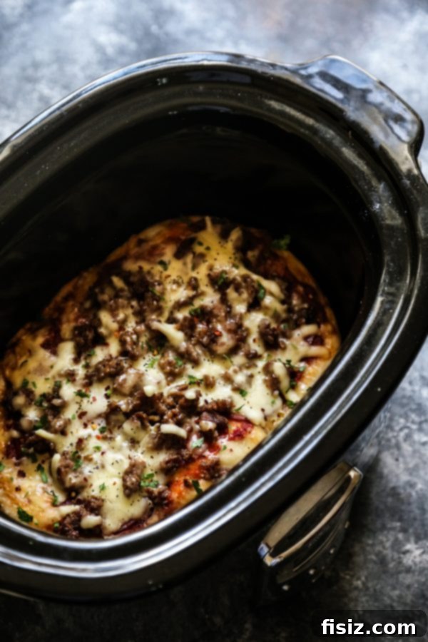 Ultimate Slow Cooker Meat Lovers Pizza 5 Spreading dough in a slow cooker for pizza
