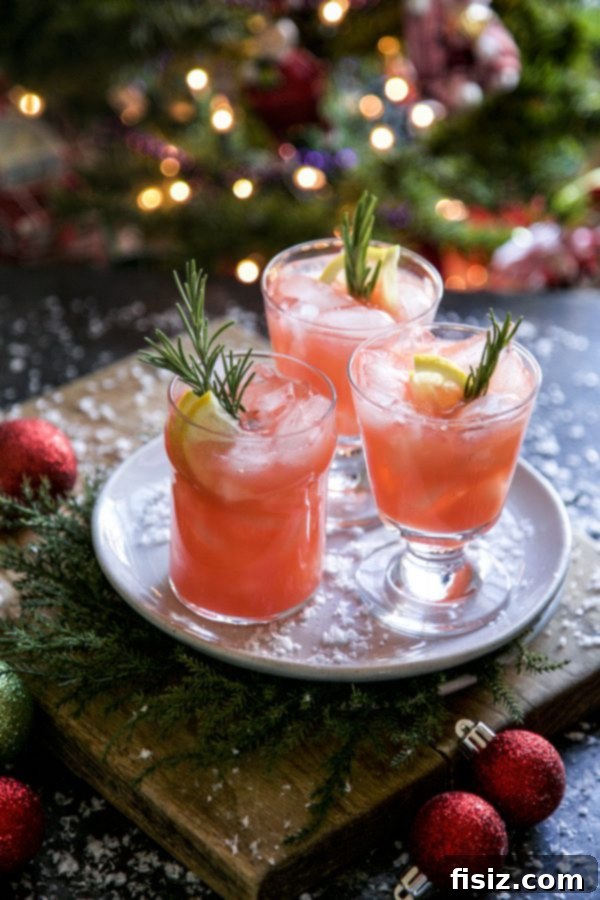 A large punch bowl filled with Christmas Morning Punch, garnished with fresh rosemary and lemon slices.