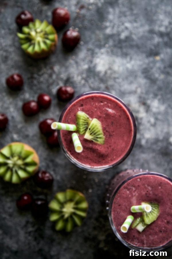Two glasses of Vanilla Superfruit Protein Smoothie garnished with kiwi