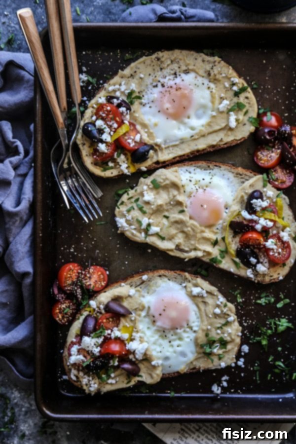 Mediterranean Egg Nest Toast with Hummus 3 Close-up view of Mediterranean Egg-in-a-Hole Toast featuring a perfectly cooked egg and a generous spread of hummus