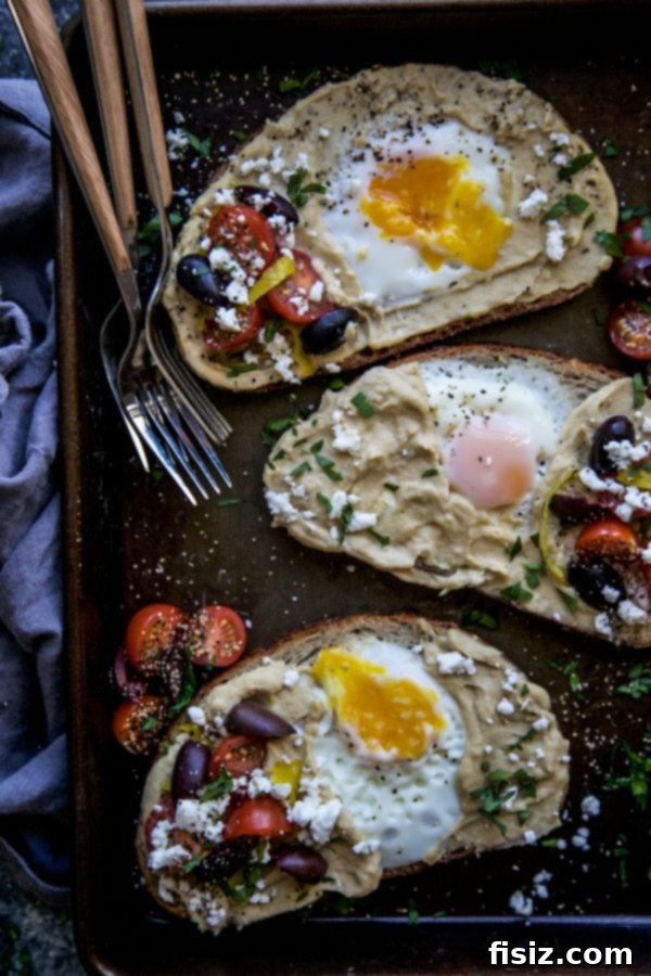 Mediterranean Egg Nest Toast with Hummus 5 Beautifully plated Mediterranean Egg-in-a-Hole Toast with a vibrant array of Mediterranean toppings