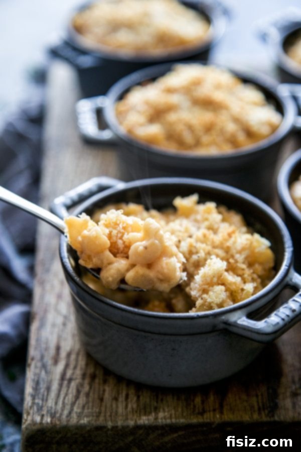 Dorothy Lynch's Signature Mac & Cheese 6 A close-up of a single serving of Dorothy Lynch Mac & Cheese in a small cocotte, showcasing the bubbling cheese and crunchy top.