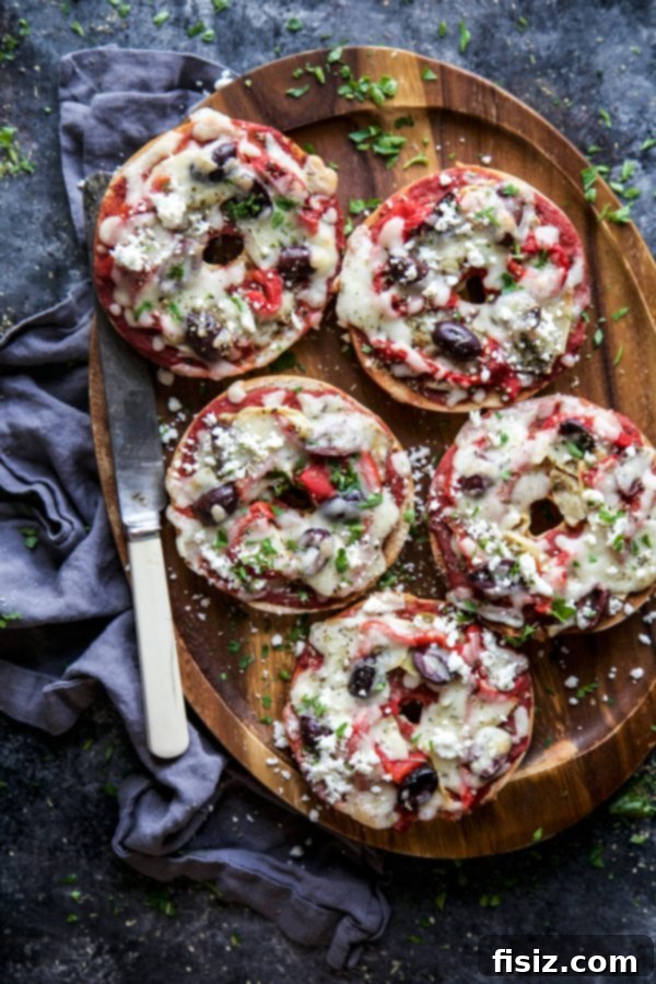 A single Greek Pizza Bagel on a white plate