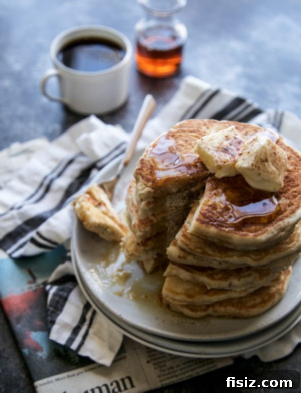 Fragrant Vietnamese Coffee Pancakes with Whipped Cinnamon Butter 6 Close-up of a hand reaching for a Vietnamese Coffee Pancake, suggesting they are irresistible without a fork