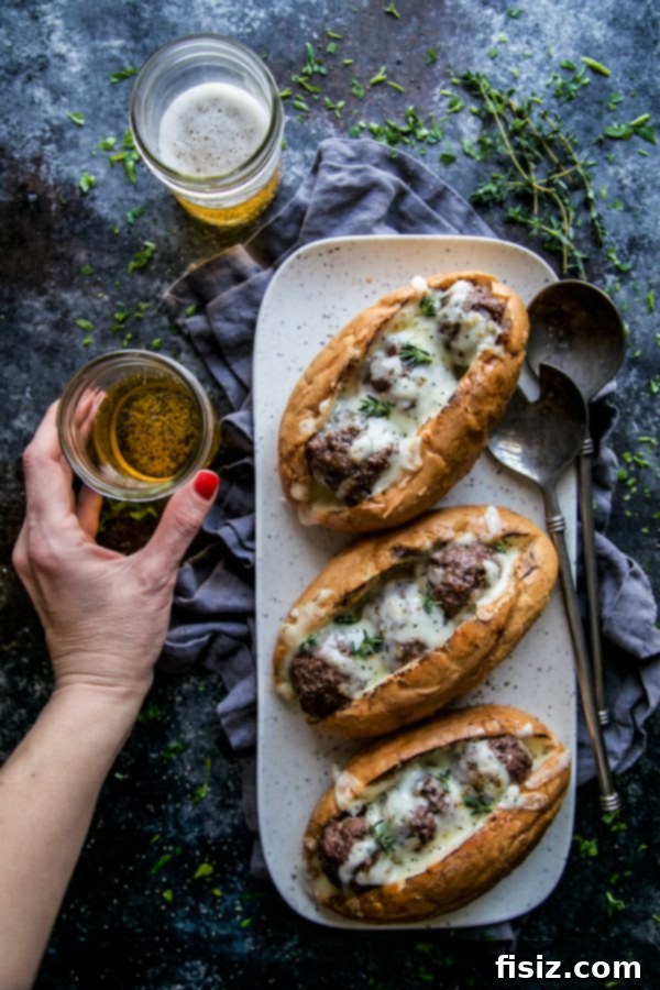 French Onion Meatball Sub Melts 6 A delicious French Onion Meatball Sub cut in half, revealing the juicy meatballs and melted cheese