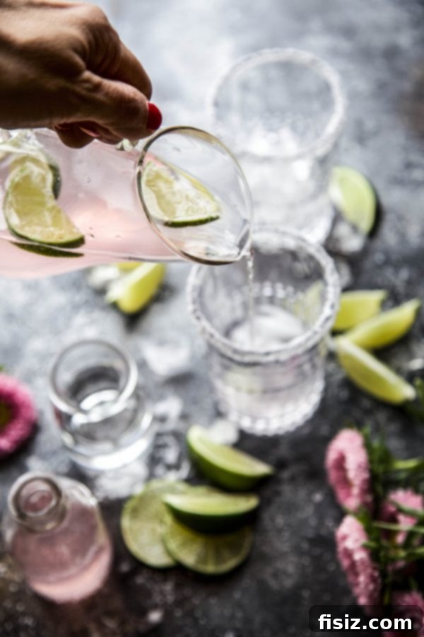 Blushing Citrus Margarita 4 Pink Lime Margaritas in glasses, ready to be served outdoors, emphasizing their party-ready nature.