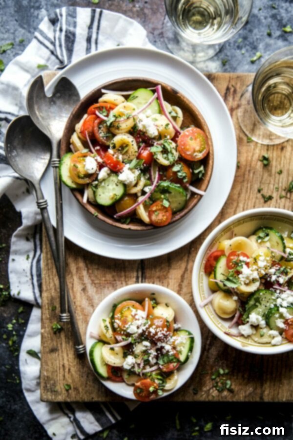 Vibrant Greek Bruschetta Pasta Salad 2 Freshly prepared Greek Bruschetta Pasta Salad with cherry tomatoes and feta in a rustic bowl