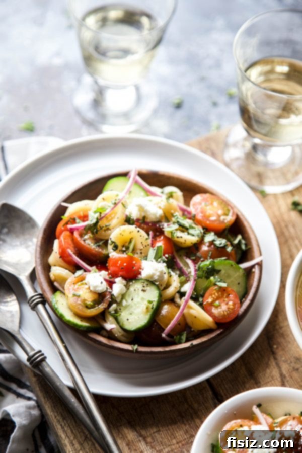 Vibrant Greek Bruschetta Pasta Salad 3 Close-up of fresh ingredients for Greek Bruschetta Pasta Salad, including vibrant tomatoes, crisp cucumbers, and fragrant basil