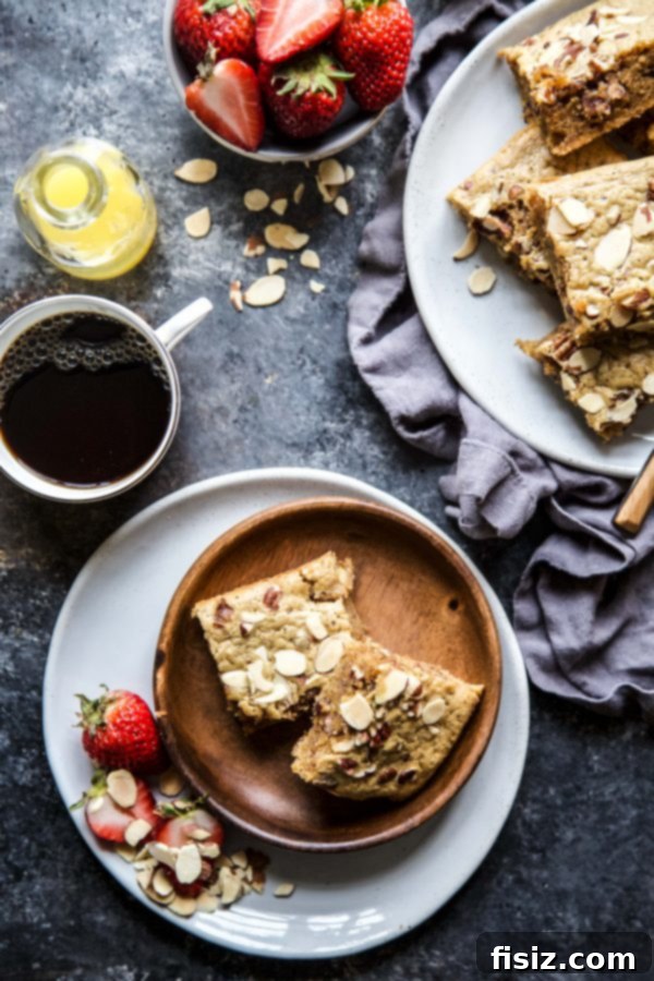 Sunrise Blondie Protein Bars 3 Hand holding a plate with a freshly baked Breakfast Blondie Protein Bar.