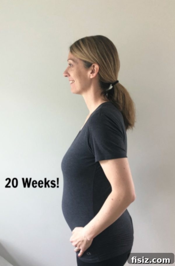 Mid-Pregnancy Check-in: Weeks 19-22 4 Pregnancy belly view at 20 weeks with hands gently placed on it.