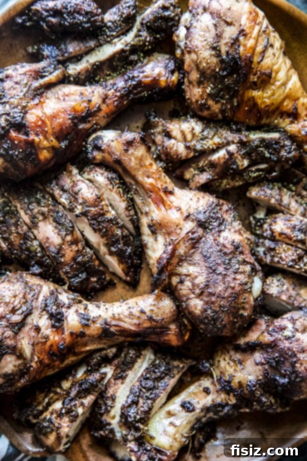 Spicy Jerk Chicken with Coconut Rice and Peas 3 Close-up of perfectly roasted jerk chicken with crispy skin and juicy meat.
