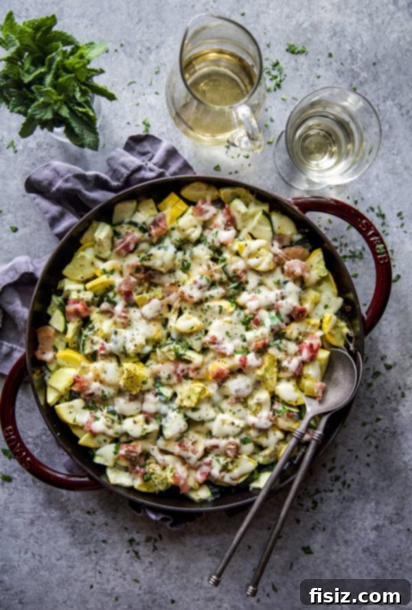 Smoky Cheesy Summer Squash Bake 6 A single serving of Cheesy Bacon Summer Squash on a white plate, garnished with fresh herbs