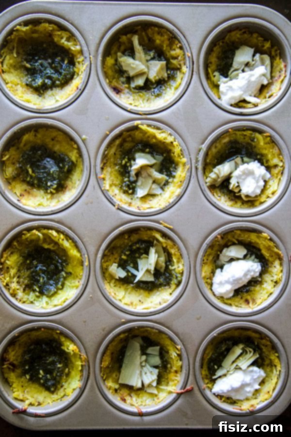 Hand holding a fresh Burrata and Pesto Spaghetti Squash Muffin Pizza, ready to eat