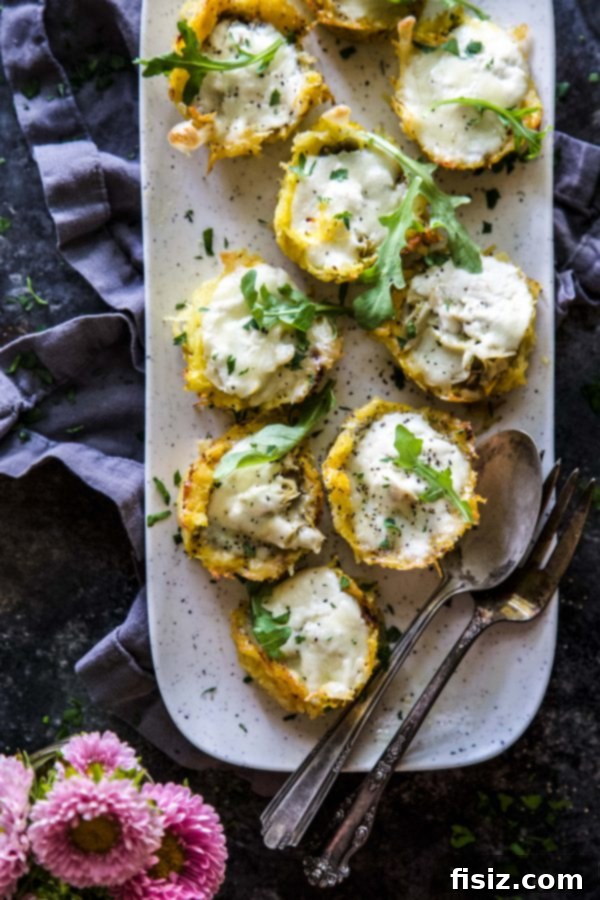 Variety of Burrata & Pesto Spaghetti Squash Muffin Pizzas arranged on a dark baking sheet