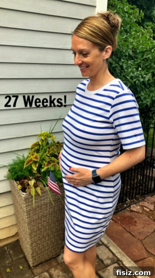 My Bump Update Weeks 23-27 11 A pregnant woman, looking reflective, standing next to a wall, showing the emotional side of pregnancy.
