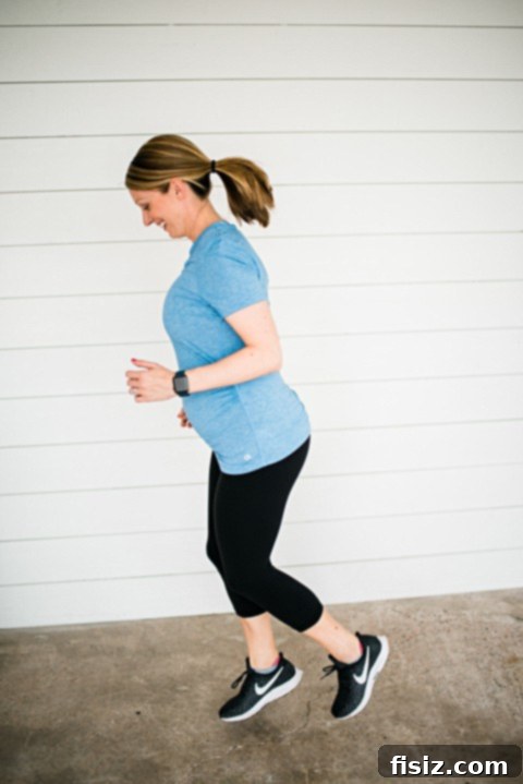 My Bump Update Weeks 23-27 4 Pregnant woman in activewear, showcasing her baby bump in a relaxed outdoor setting.