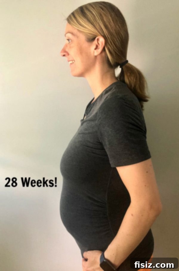 Third Trimester Milestones: Weeks 28-32 3 Pregnant woman showcasing her growing belly at 28 weeks, marking the start of her third trimester.