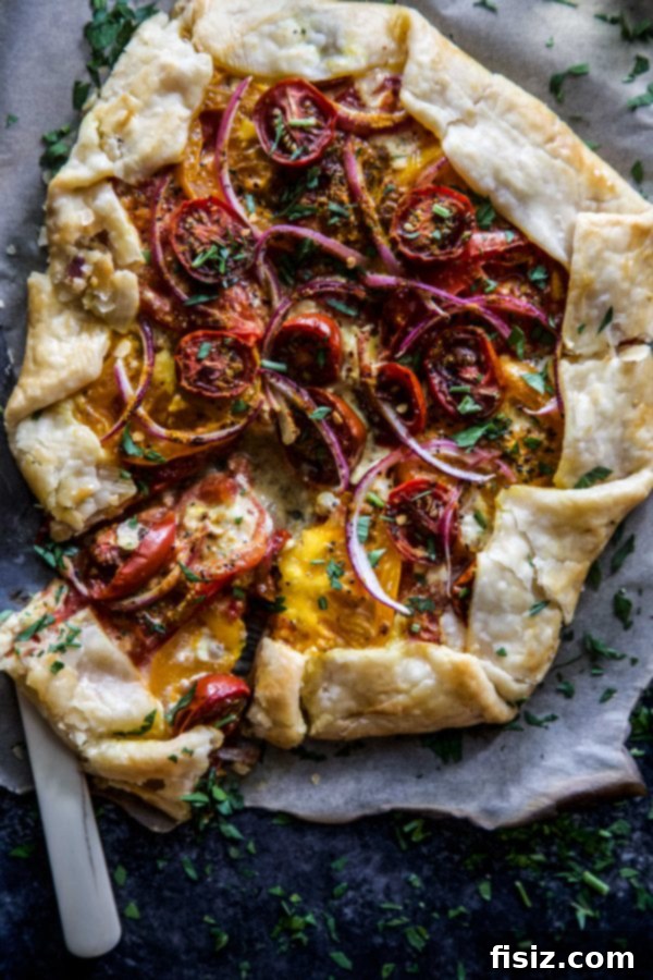 Savory Curried Tomato Tart 3 Overhead view of a slice of Roasted Curry Tomato Galette on a plate, showing the layers of tomato and cheese