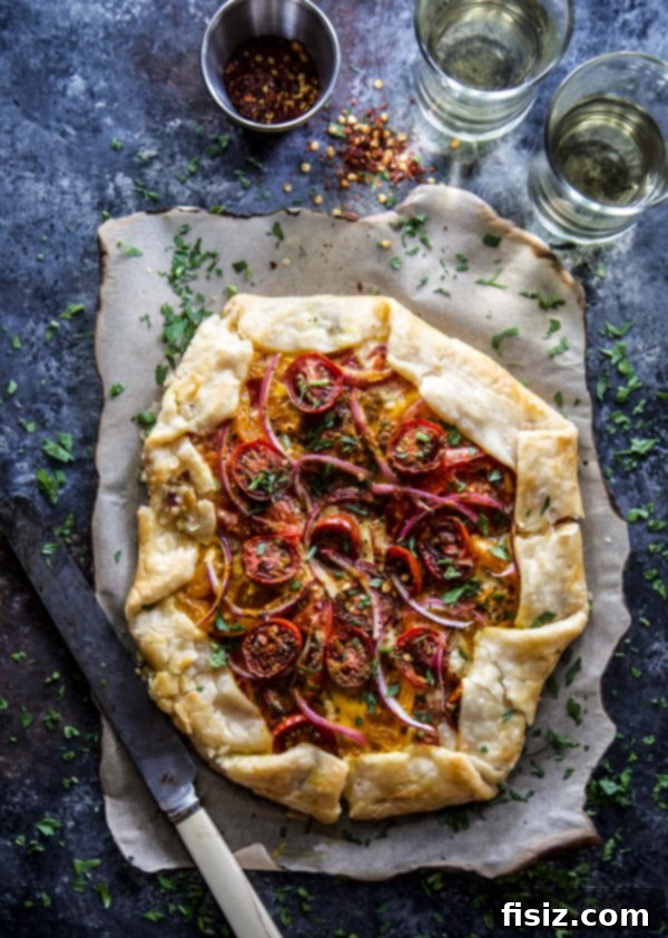 Savory Curried Tomato Tart 6 A close-up shot of the raw Roasted Curry Tomato Galette before baking, showing the folded crust and fresh ingredients