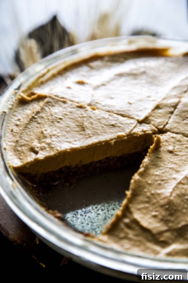 Velvet Pumpkin and White Chocolate Mousse Pie 3 Overhead view of a whole Pumpkin and White Chocolate Mousse Pie on a rustic wooden surface