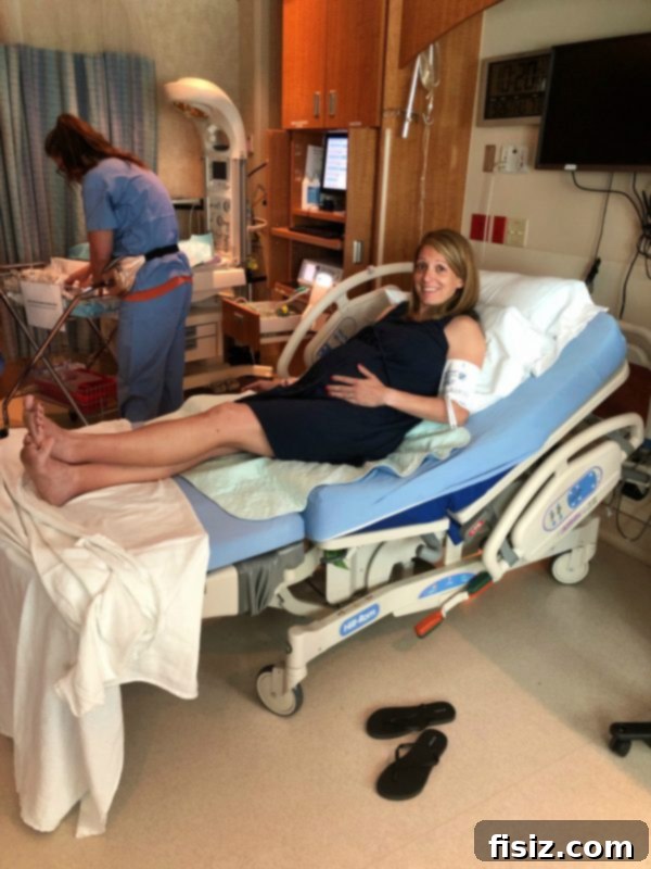 The Wonderful Arrival of Charlie 5 A pregnant woman in a hospital gown, smiling while holding her belly, with her partner beside her.