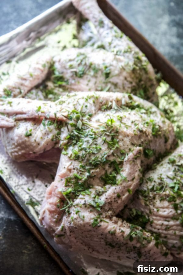 Crispy Herb-Roasted Spatchcock Turkey 4 Spatchcock Herbed Turkey on a baking sheet, ready for the oven, covered in a rich herb butter