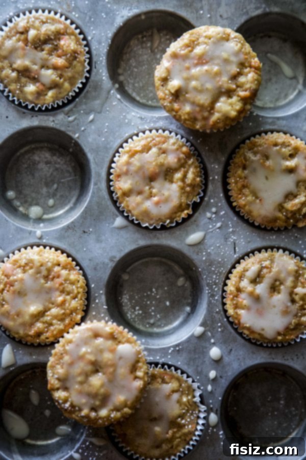 Bright Carrot Apple Muffins with Zesty Citrus Glaze 4 Freshly baked Carrot Apple Muffins cooling on a wire rack, waiting for glaze