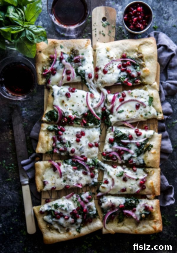 Vibrant Winter Greens and Pomegranate Pizza 4 Close-up shot of Winter Greens and Pomegranate Pizza with fresh pesto base