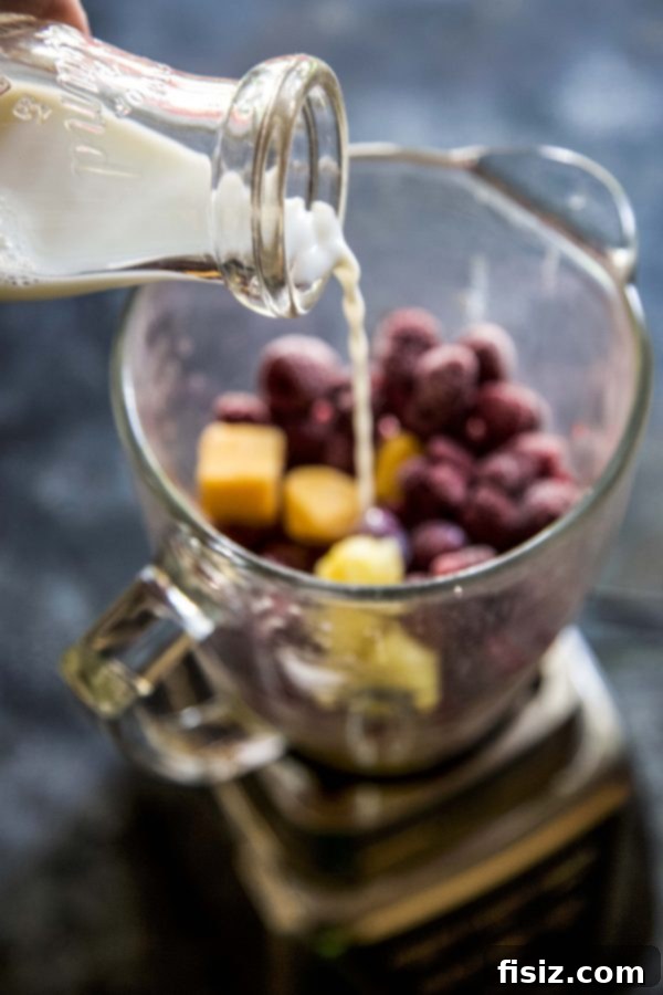 Tropical Raspberry Mango Protein Fuel 4 A close-up view of the creamy, vibrant texture of a freshly blended Raspberry Mango Protein Smoothie.