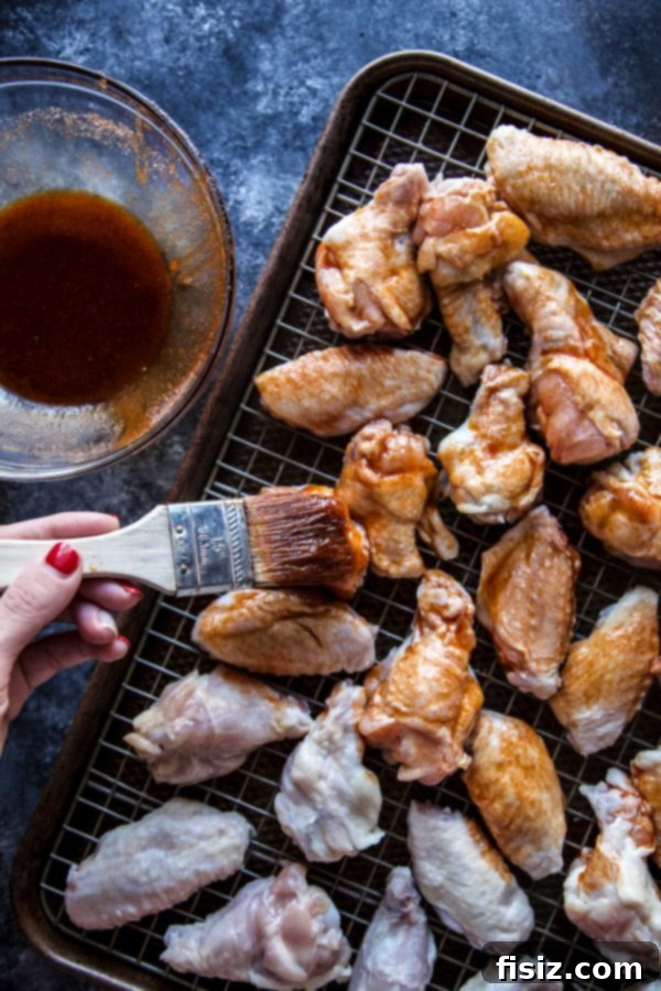 A close-up of crispy baked chicken wings on a wire rack, perfectly glazed.