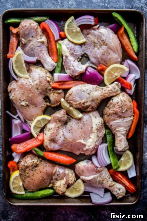 Effortless Greek Sheet Pan Chicken 3 Close-up of marinated chicken and vegetables on a baking sheet
