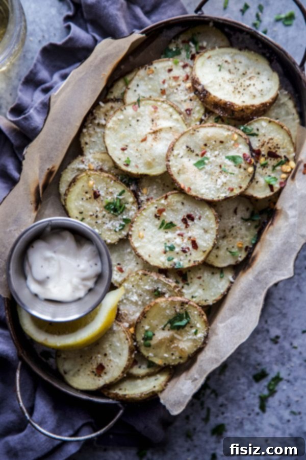 Oven-Baked Parmesan Pepper Crisps 3 Close-up of freshly baked potato chips sprinkled with Parmesan and black pepper