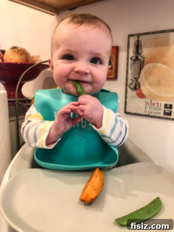 Half a Year with Charlie 9 Baby Charlie happily exploring a soft food, possibly hummus or tzatziki, during her baby-led weaning journey.