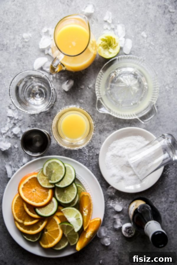 Sparkling Orange Tequila 4 Three Mimosa Margaritas in glasses, with a pitcher and a bowl of limes in the background.