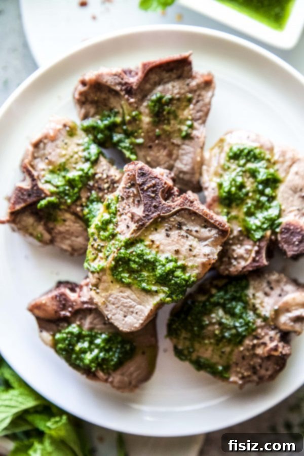 Pan-Seared Lamb Loin with Zesty Spinach Salsa Verde 3 Close-up of grilled lamb loin chops cooking on a barbecue, showing perfect sear marks.