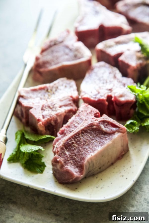Fresh lamb loin chops seasoned with salt and pepper, ready for the grill