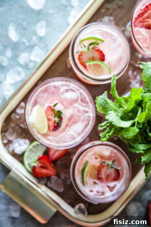Crimson Gin Tonic 5 A person pouring gin into a glass with strawberry syrup and ice