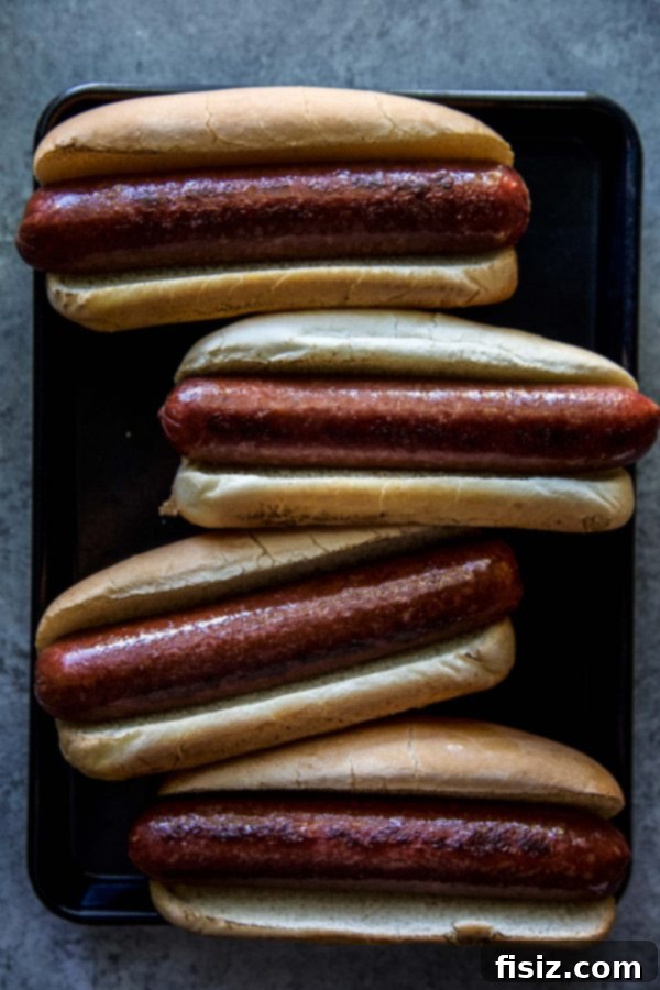 Loaded Barbecue Bison Hot Dogs 5 A vibrant platter of grilled bison hot dogs, buns, and topping ingredients