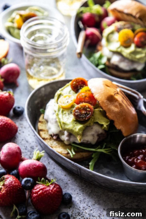 Garden Fresh Guacamole Burger 3 Two hands holding a Summer Garden Guacamole Burger with a vibrant green guacamole topping