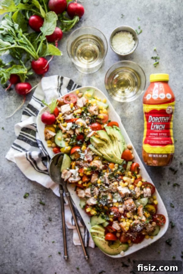 Dorothy Lynch Glazed Chicken and Zesty Summer Chickpea Salad 2 A vibrant bowl of Summer Chickpea Salad with Dorothy Lynch Grilled Chicken, showcasing fresh vegetables and grilled chicken pieces.