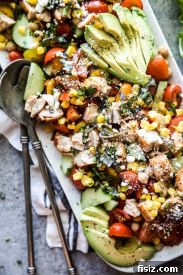 Dorothy Lynch Glazed Chicken and Zesty Summer Chickpea Salad 3 Close-up of fresh summer vegetables including avocado, tomatoes, corn, and cucumber.