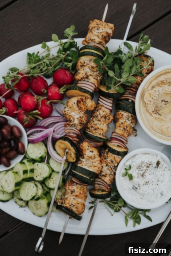 Greek Chicken Souvlaki 12 A full view of the grilled Greek Chicken Skewers on a serving board with fresh ingredients.