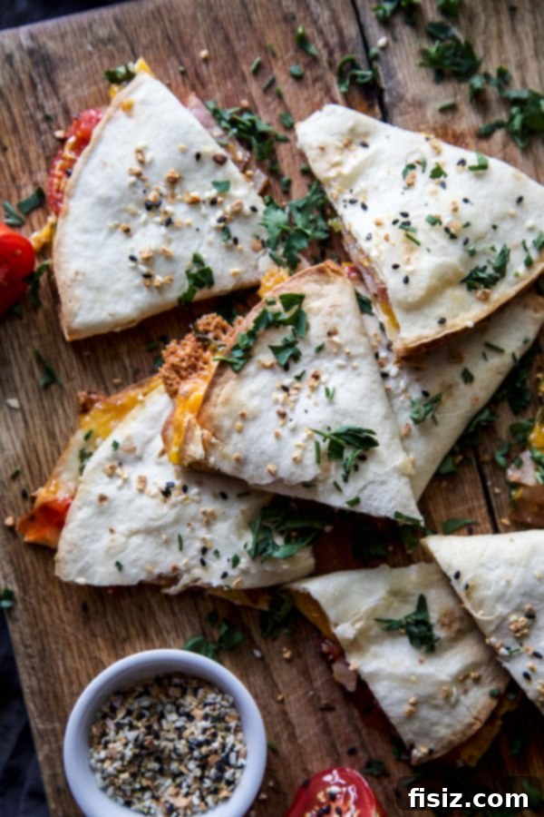 Overhead shot of an Everything BLT Baked Quesadilla filled with bacon, lettuce, tomato, and melted cheese, garnished with fresh parsley.
