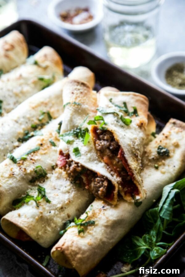Baked Meat Lover Pizza Rolls 2 Crispy baked meat lover's pizza taquitos arranged on a baking sheet, golden brown and ready to eat.