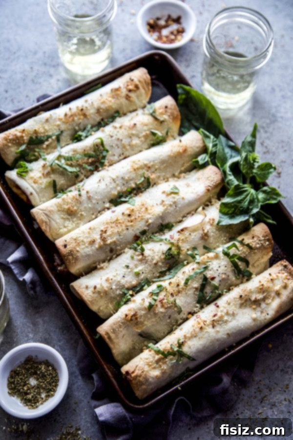 Baked Meat Lover Pizza Rolls 6 A vibrant overhead shot of baked pizza taquitos, garnished with fresh basil, ready for a delicious meal.