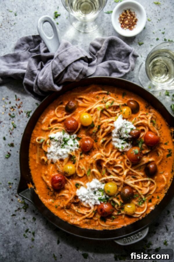 Indulgent Roasted Red Pepper Alfredo with Burst Tomatoes and Creamy Burrata 2 Close-up of Roasted Red Pepper Alfredo pasta with burst tomatoes and burrata, garnished with fresh basil.