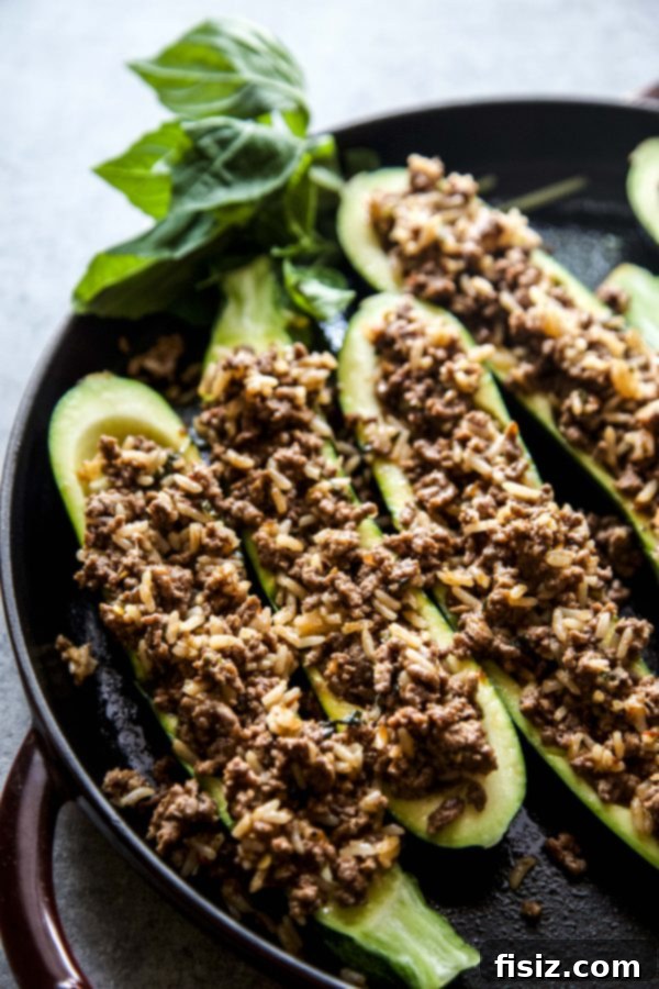 Thai Basil Beef Zucchini Boats 4 Overhead view of a baking dish filled with Thai Basil Beef Stuffed Zucchini boats, ready to be served.